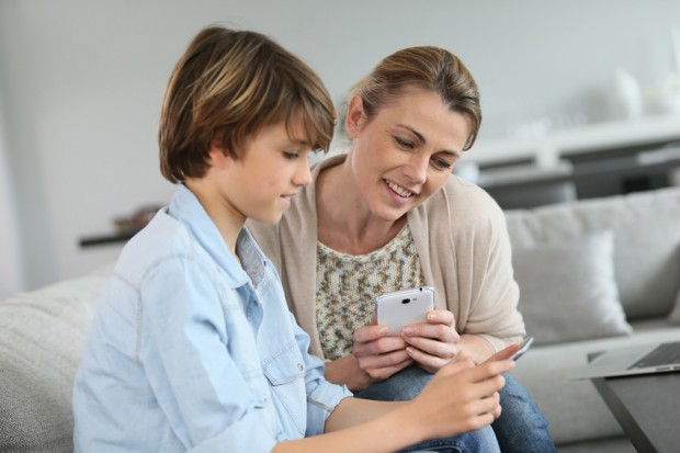 Mother and teenage boy playing with smartphone